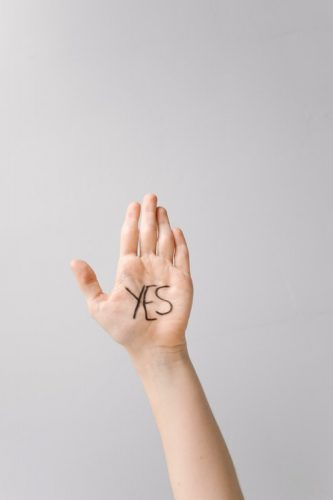 A hand with a written word "yes"